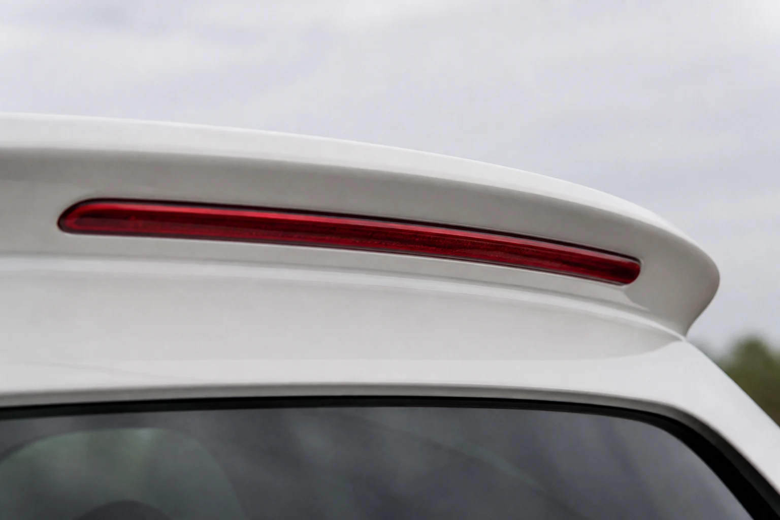 Rote dritte Bremsleuchte im Heckspoiler eines Abarth 500 – hinter dieser Leuchte sitzt eine W5W (mit KI erzeugt)