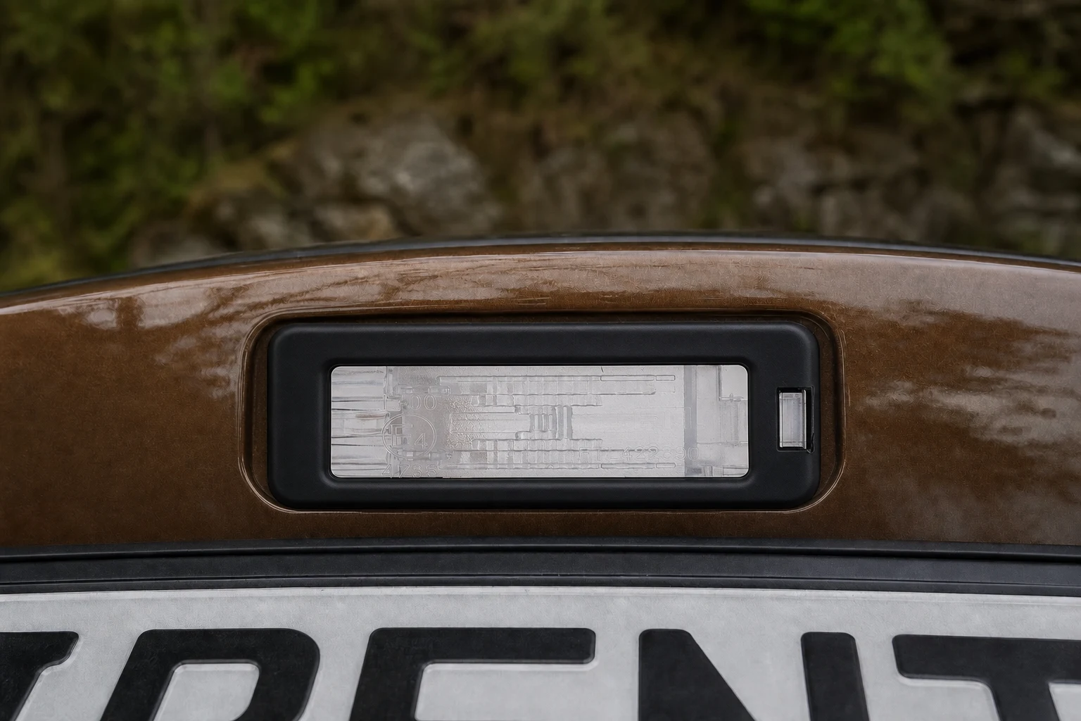 Kennzeichenbeleuchtung des Dacia Duster 1. Gen; der rote Pfeil zeigt auf die Fassung