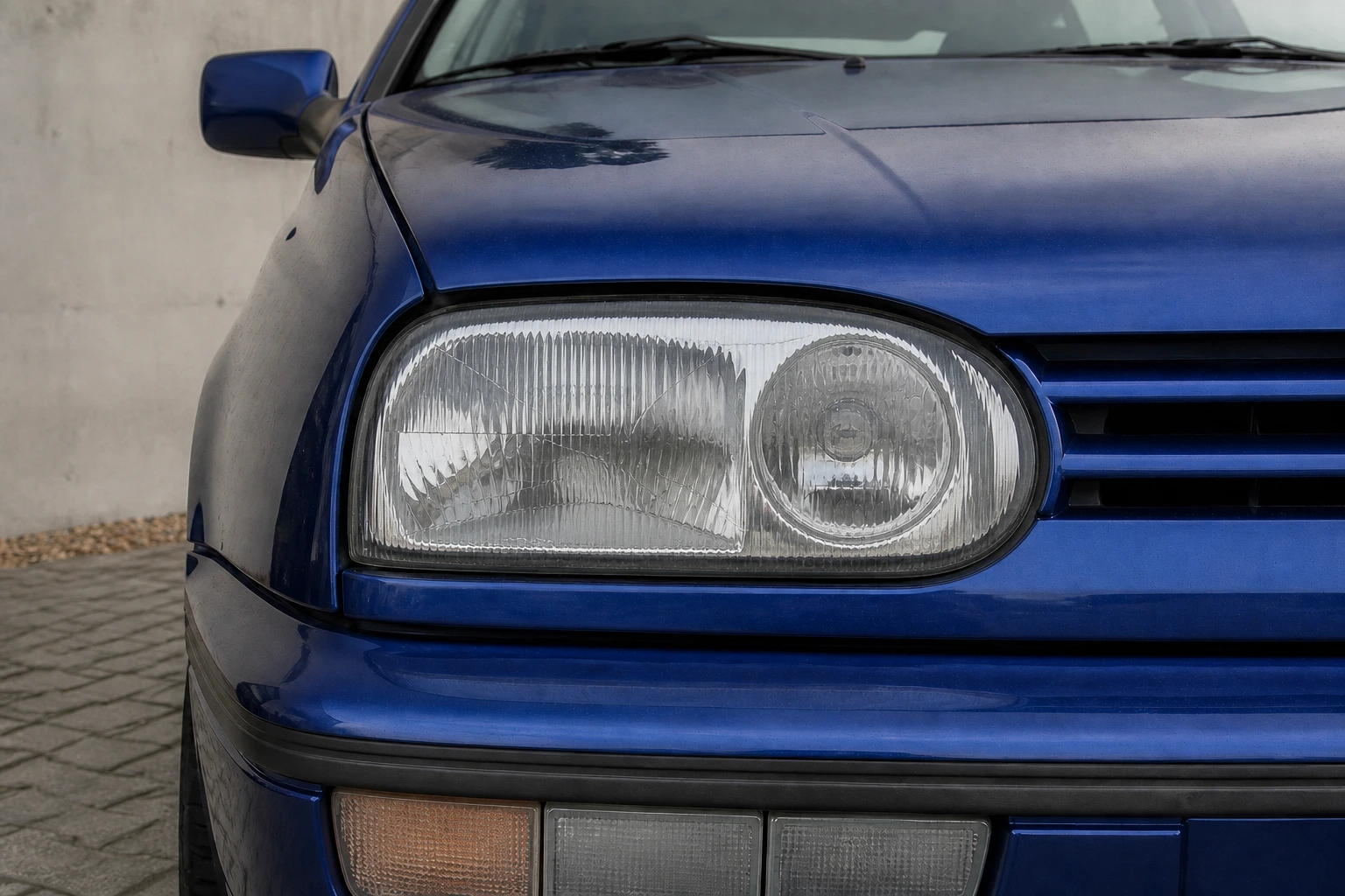 Abblendlicht des VW Golf 3; der rote Pfeil zeigt auf die Fassung (mit KI erzeugt)